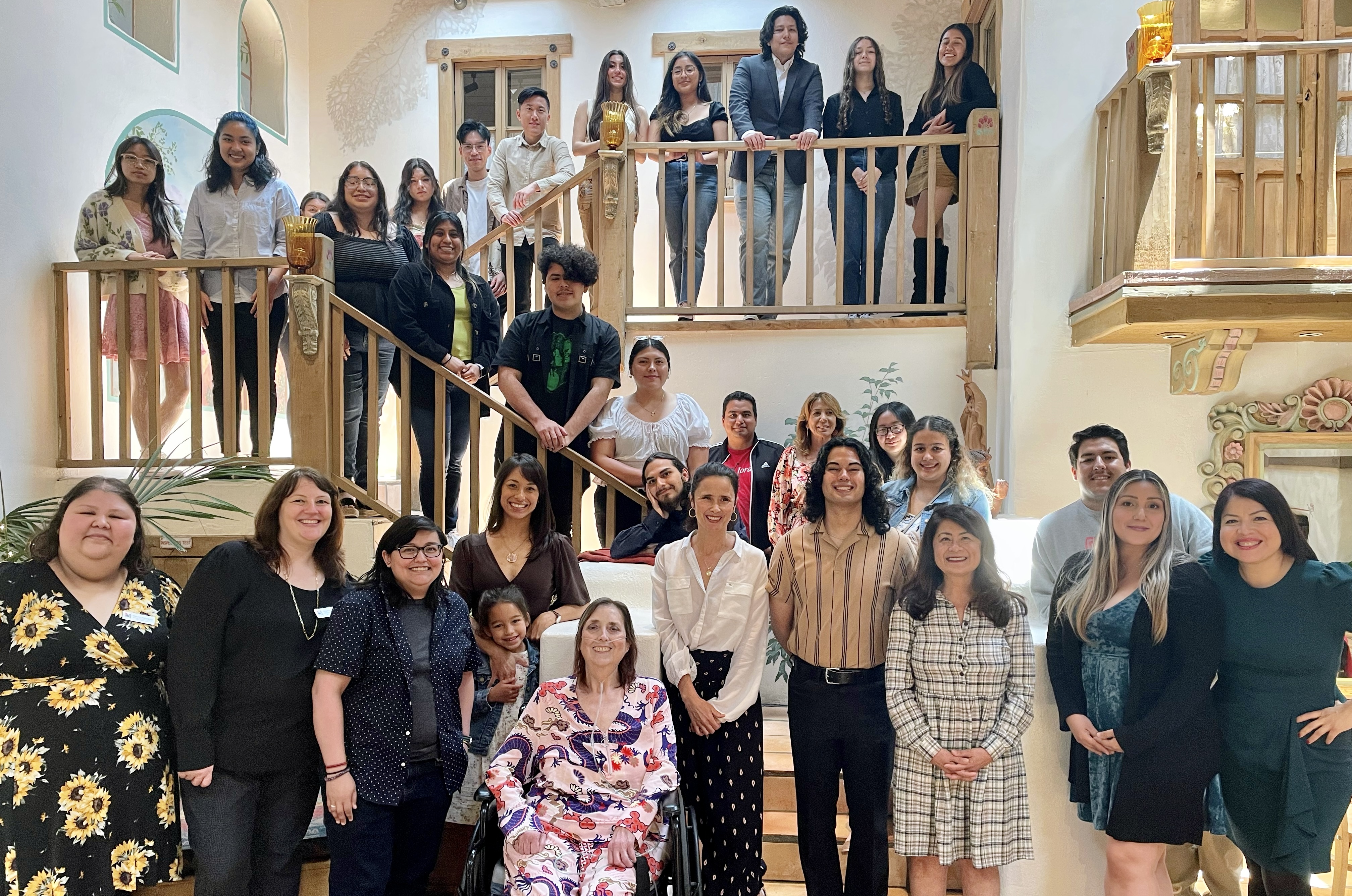SAC ULink students pose for their Spring 2023 End of the Year Celebration at the Hacienda on a staircase and balcony setting.